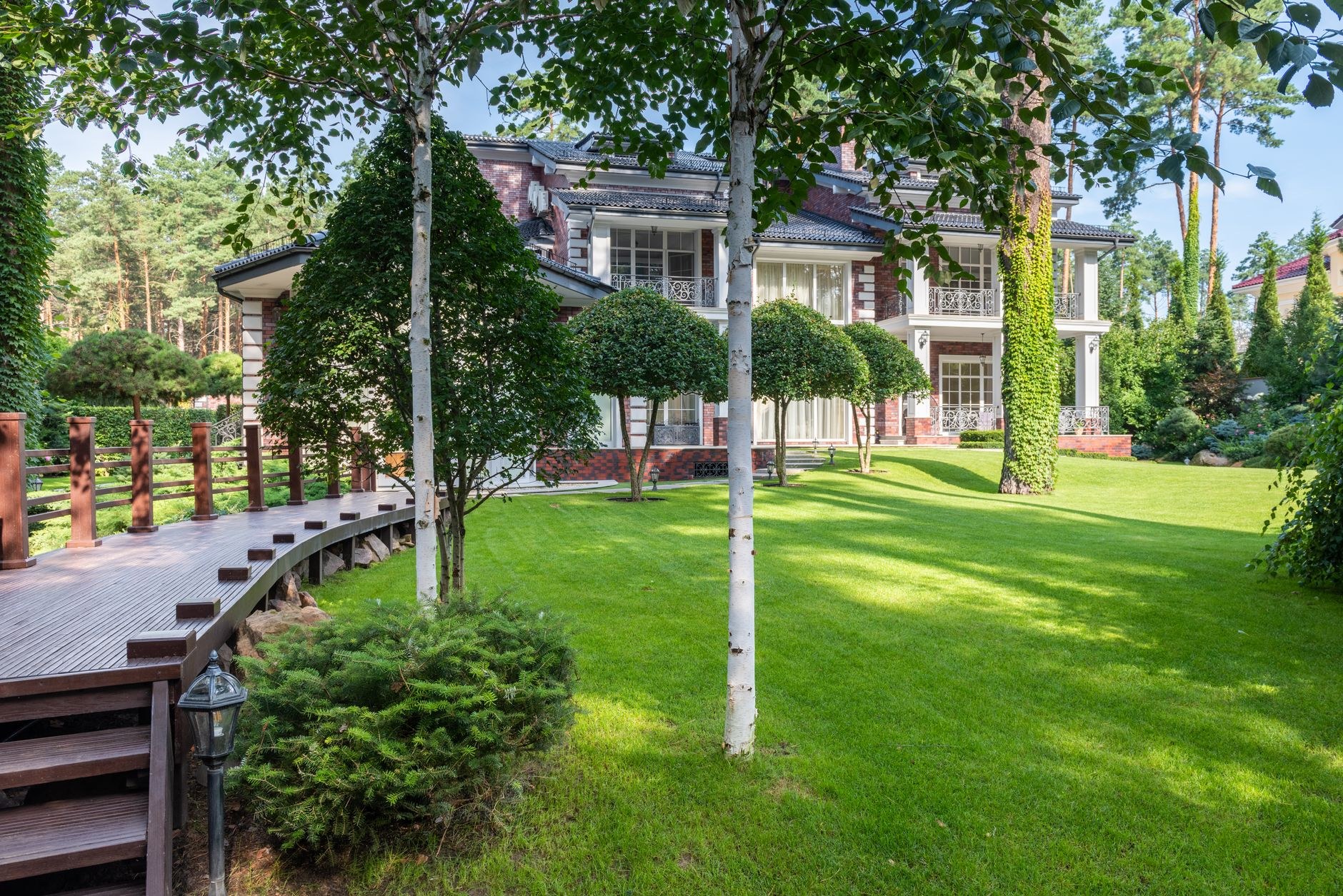 Manicured lawn sweeping to a home with shaped trees